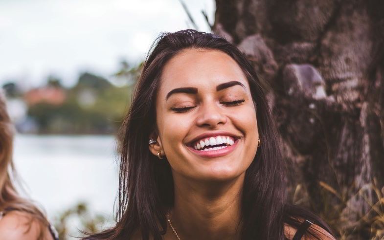 Fille au sourire très blanc après être passée au vapotage