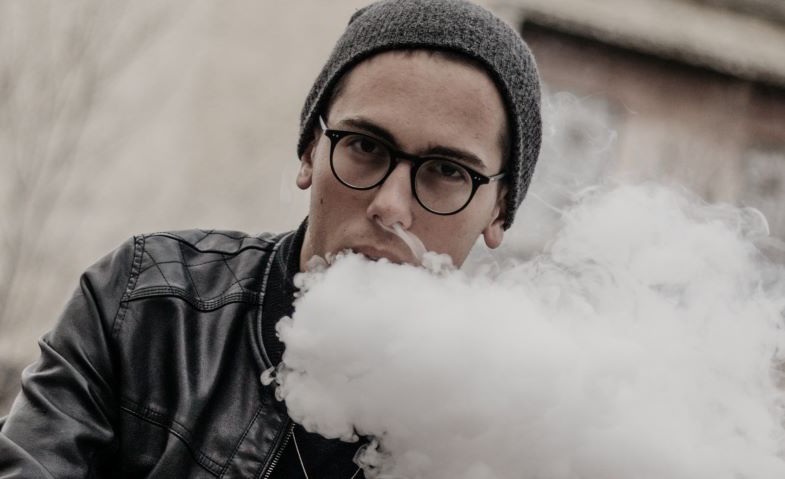 Garçon qui fume avec une cigarette électronique sans nicotine
