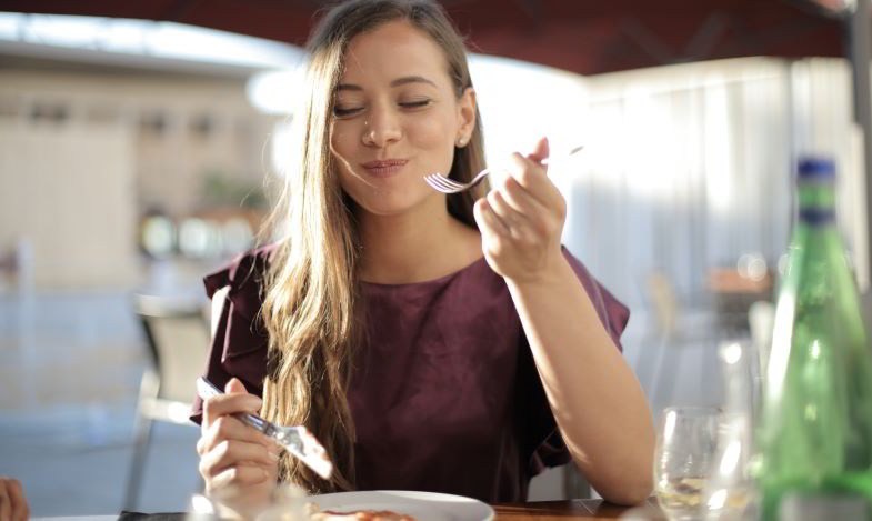 femme qui apprécie le goût et l'odeur des aliments après avoir arrêté de fumer