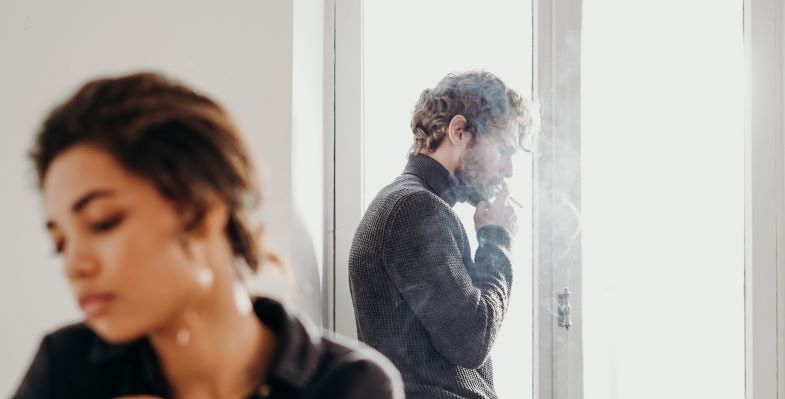 Une femme gênée par la fumée secondaire