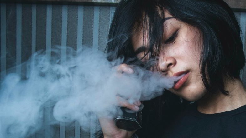 Une fille qui fume avec un box mod