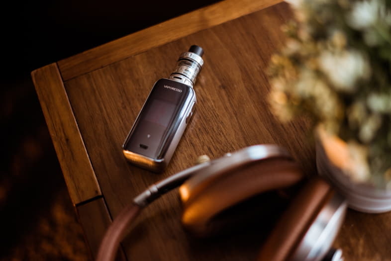 Cigarette électronique posée sur une table basse en bois