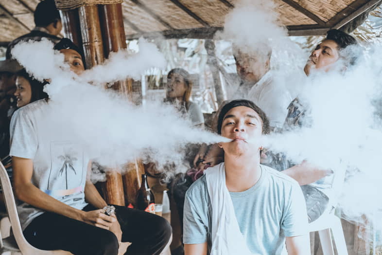 Un groupe de jeunes en train de faire Cloud Chasing, émettant de grands nuages de vapeur