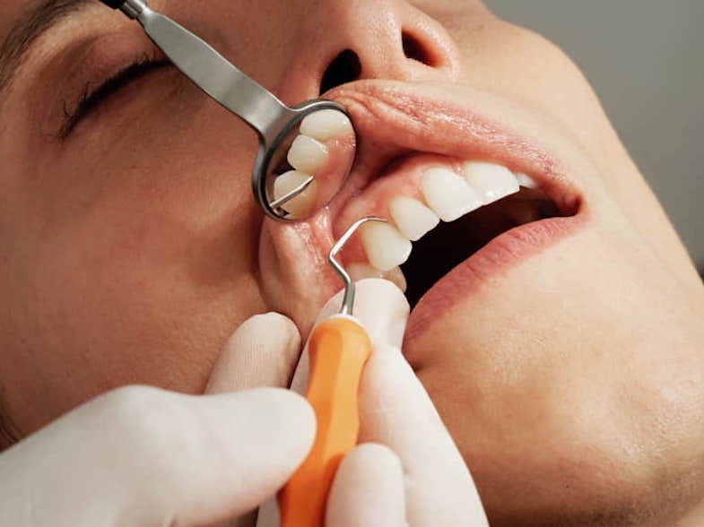 Un dentiste examine la santé bucco-dentaire d'une patiente | Terpy